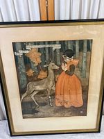 Full view of framed vintage print with girl praying near deer in forest.