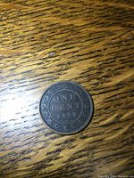 Reverse of the 1882 Canadian one cent coin displaying denomination and date surrounded by a wreath.