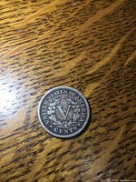 Reverse side of the 1907 US Liberty Head Nickel showing the Roman numeral V symbolizing 5 cents, surrounded by a wreath and text details.