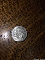 Close-up photo of the obverse side of the 1963 silver Canadian 50 cent coin showing the detailed Canadian coat of arms, lightly circulated condition visible.