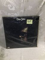 Front view of the Elton John album showing a close-up portrait with 'Elton John' text.