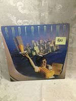 Front cover of Supertramp Breakfast in America LP album showing waitress and breakfast cityscape artwork with a 900 price tag
