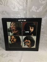 Front cover of The Beatles Let It Be vintage vinyl LP album showing band members and album title on black background.