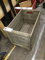 Photo showing the full inside and outside structure of the rectangular weathered wooden crate with hand cut handle slots.