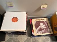 Two stacks of vinyl records labeled 'Mixed' and 'Pop / R&B' showing a Diana Ross Greatest Hits album on top of the right pile.