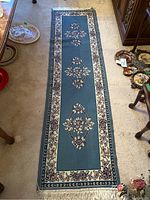 Full view of the blue floral patterned area rug runner laid out on the floor showing its length and pattern.