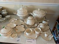 Photo showing entire ceramic serveware set, including tureen with lid and ladle, casserole server with lid, candle holder, serving bowls, condiment plates and platter, teapot, cups and saucers, sugar bowl, and creamer pitcher.