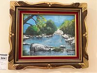 Full view of the framed painting showing the landscape scene and decorative frame.