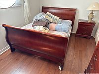 Full assembled bed frame with mattress and scattered bedding