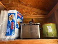Electric deep fryer and Crockery Chef slow cooker with unopened napkins beside them, showing lot contents and condition.