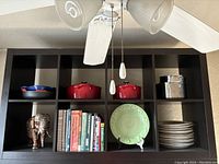 Front view of the IKEA Expedit bookcase showing 8 cubes filled with various kitchen items and books.
