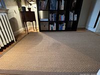 Close-up view showing texture and colour-bound edge of sisal rug in earth tone shades.