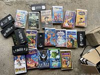 Photo showing a spread of various VHS tapes including Disney classics and other titles such as Batman and Air Bud.