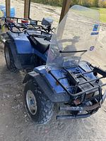 Front-left angle showing front bumper, front rack, windshield, and left front wheel