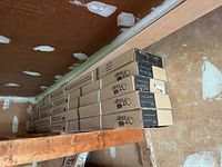 Seven stacked unopened boxes of Vintage hardwood flooring with oak leaf print on boxes.