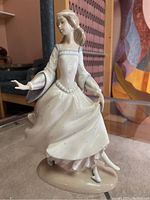 Front and angle view of the Lladro porcelain figurine showing the full figure and dress details