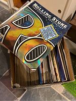 Box filled with many Rolling Stone magazines, showing the holographic 40th Anniversary cover on top.