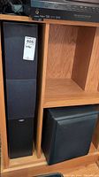 Energy XL-250 speakers and Klipsch subwoofer in wood shelving unit.