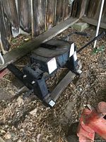 Front-facing view of hitch head on wooden boards showing frame, slide rails and overall wear