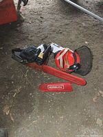 Top-down view showing chainsaw, bar cover, helmet and face shield