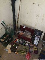 Overview of tackle boxes, rod, nets and books against wall