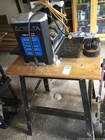 Front view showing planer on wooden base with ear muffs