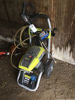 Front angle of unit showing frame, wheels, motor housing, hose and wand wrapped on handle