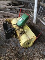 Top-side perspective showing yellow housing and green chute assembly with belt guard