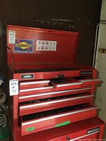 Front view of red Mastercraft top toolbox chest with hinged lid open and drawers partially extended