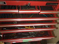 Red Mastercraft upper toolbox with multiple drawers and tools inside, visible sockets and screwdrivers.