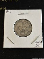 Reverse side of the 1940 GB silver one shilling coin showing crowned lion on crown and denomination.