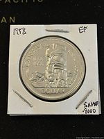 Obverse side of the 1958 Canadian silver dollar showing the totem pole design and inscriptions.