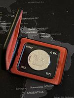 1973 Canadian silver coin in display case with red cover, showing coin inside plastic holder.