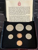 Front view of the seven Canadian specimen coins from 1873-1973 in black box with insert text describing the set and historical context.