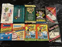 All 10 unopened baseball trading card packs from 1991-94, displayed on black map background.