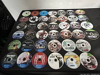 Photo showing multiple game discs arranged in rows with various titles from different consoles visible.