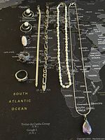 Photo showing all jewelry pieces arranged on a map background, including necklaces, rings, bracelets, and earrings.