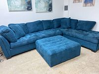 Full view of teal blue L-shaped sectional with matching square ottoman