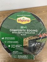 Front view showing product branding and key features including depth indicator, dimensions, and included stakes.