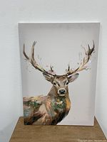 Full view of the deer painting on canvas showing the deer with antlers and decorative floral accents.