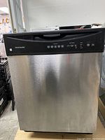 Front view of Frigidaire stainless steel dishwasher with black control panel and buttons visible.