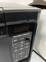 Close-up of Hamilton Beach microwave digital control panel showing preset options and LED display.