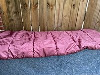 Sleeping bag fully laid out showing maroon quilted outer fabric.