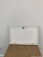Folded mounted wall desk showing white exterior panel and wood frame.