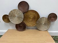 Front image showing the full arrangement of seven circular metal discs clustered together in varied metallic tones.