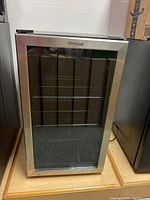 Front view of the Whirlpool beverage cooler showing stainless steel frame and glass door.