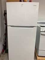 Front view of white Frigidaire refrigerator in garage setting