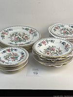 Full set of Aynsley Pembroke dinnerware with three groups of stacked plates and bowls, showcasing size and number variations.