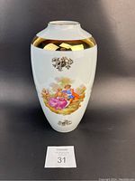 Front view of the porcelain vase showing romantic couple painted scene with gold accented band around the neck.