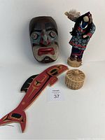 Photo showing full lot: wooden carved mask, signed Mohawk doll in traditional costume, painted wooden fish, and woven basket